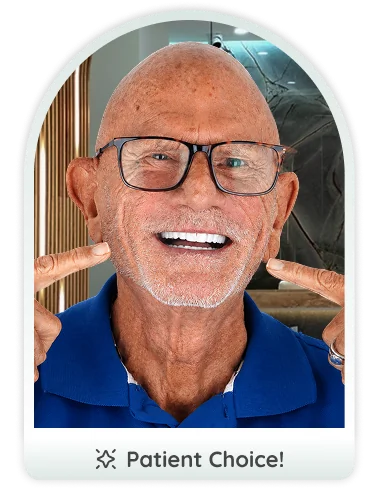 Elderly man smiling and pointing at his zirconia dental procedure results.