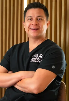Male dental specialist standing with arms crossed at Esthetic Dentistry clinic.
