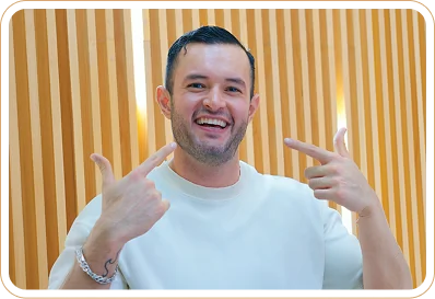 Happy male patient gesturing at his smile after dental procedure.