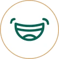 Green line-art icon of a wide, smiling mouth showing teeth, enclosed in a thin gold circle.